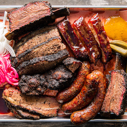 Barbecue platter featuring smoked brisket, beef ribs and sausages from Horn Barbecue
