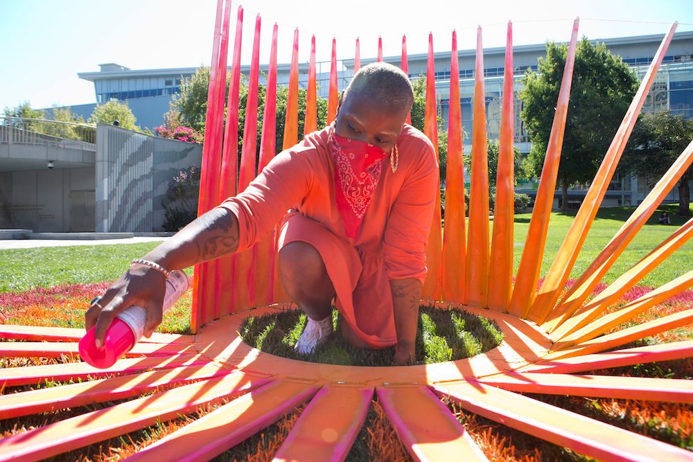 Multidisciplinary artist Tosha Stimage works on one of her 21 “Infinite Center, infinite sun” pieces on Yerba Buena Garden’s lawn.