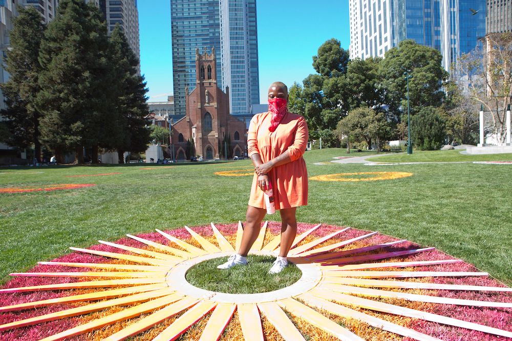 Multidisciplinary artist Tosha Stimage works on one of her 21 “Infinite Center, infinite sun” pieces on Yerba Buena Garden’s lawn.